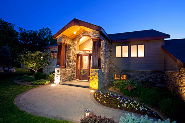 Photo of a house beautifully landscaped and lit up with landscape lighting